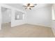 A neutral-toned living room with tile floors, ceiling fan, and an open view of the stairway at 10651 Streamside Ave, Las Vegas, NV 89129