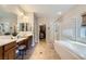 Bathroom featuring dual vanities, separate tub and shower, and access to a walk-in closet at 11165 Robin Park Ave, Las Vegas, NV 89138