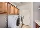 Convenient laundry room features a side-by-side washer and dryer, and storage cabinets above at 11165 Robin Park Ave, Las Vegas, NV 89138