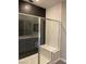 Modern bathroom featuring hexagon tile, glass enclosed shower with shower bench, and gray vanity at 11394 Ethereal Landing Ave, Las Vegas, NV 89138