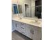 Bathroom with a double sink vanity, white cabinets, and modern fixtures and a view of a glass enclosed shower at 11394 Ethereal Landing Ave, Las Vegas, NV 89138