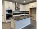 Bright kitchen with stainless steel appliances, island with sink, white cabinets, and subway tile backsplash at 11394 Ethereal Landing Ave, Las Vegas, NV 89138