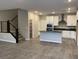 Open-concept living area showcasing modern staircase, tiled flooring, and a bright kitchen at 11394 Ethereal Landing Ave, Las Vegas, NV 89138