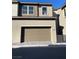 A two-car garage with a brick paver driveway in front of this two-story home at 11414 Ethereal Landing Ave, Las Vegas, NV 89138