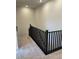 A staircase with a dark railing leading to the second floor and neutral carpeting at 11414 Ethereal Landing Ave, Las Vegas, NV 89138