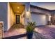 A detailed view of the home's stucco and stone facade, featuring a brick driveway and desert landscaping at 11831 Saverio Ave, Las Vegas, NV 89138