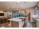 Open-concept kitchen with a large island, stainless steel sink, and views of living area at 11831 Saverio Ave, Las Vegas, NV 89138