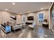 Modern living room with a brick accent wall, stylish furniture, hardwood floors, and lots of light at 11831 Saverio Ave, Las Vegas, NV 89138