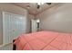 Bedroom with a light pink comforter, ceiling fan, and double door closet at 1464 Barlow Ave, Moapa, NV 89025