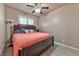 Bedroom featuring a dark wood frame bed, ceiling fan, and window with shutter blinds at 1464 Barlow Ave, Moapa, NV 89025