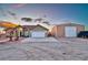 Single-story home with an attached garage, desert landscaping and a storage barn at 1464 Barlow Ave, Moapa, NV 89025