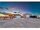 Desert home at dusk featuring a two car garage, low water landscaping and a barn at 1464 Barlow Ave, Moapa, NV 89025