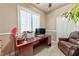 Functional home office with a large desk, comfortable seating, and natural light from the shuttered window at 1464 Barlow Ave, Moapa, NV 89025