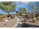 Landscaped backyard with a walkway leading to a relaxing seating area surrounded by desert plants and gravel at 1564 Fieldbrook St, Henderson, NV 89052