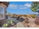 Landscaped backyard with cactus, stone pathway, and partial view of covered patio at 1564 Fieldbrook St, Henderson, NV 89052