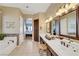 Well-lit bathroom with double vanity, soaking tub, and elegant fixtures, providing a spa-like experience at 1564 Fieldbrook St, Henderson, NV 89052