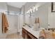 Bright bathroom with a bathtub, vanity with dual sinks, updated lighting, and neutral color palette at 1564 Fieldbrook St, Henderson, NV 89052