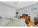 Well-lit bedroom showcasing hardwood floors, a ceiling fan, and a wooden cabinet under a wall-mounted TV screen at 1564 Fieldbrook St, Henderson, NV 89052