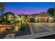 Elegant single-story home showcasing a two-car garage, lush tropical landscaping, and a well-maintained driveway at 1564 Fieldbrook St, Henderson, NV 89052