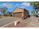 Garage of a well-maintained home with manicured landscaping, desert trees, and ample parking space at 1564 Fieldbrook St, Henderson, NV 89052