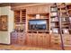 Built-in wooden shelves and cabinets with TV and wet bar, creating an entertainment space at 1564 Fieldbrook St, Henderson, NV 89052