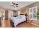 Inviting main bedroom showcasing a ceiling fan, dark wood floors, and a sliding barn door to an en-suite bathroom at 1564 Fieldbrook St, Henderson, NV 89052