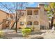 Multi-level condo building with exterior stairs, tan stucco, a red tile roof and green landscaping at 1851 Hillpointe Rd # 2922, Henderson, NV 89074