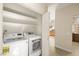 Practical laundry room with new washer and dryer and shelving units at 1851 Hillpointe Rd # 2922, Henderson, NV 89074