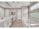 Bright bathroom featuring double sinks, quartz countertop, tile floors and soaking tub at 2153 Havensight Ln, Henderson, NV 89052