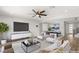 This staged living room offers modern decor, hardwood floors, ceiling fan, and abundant natural light at 2153 Havensight Ln, Henderson, NV 89052