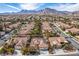 Aerial view of a community featuring red tile roofs, palm trees, desert landscaping, and mountain views at 2329 Quartz Peak St, Las Vegas, NV 89134