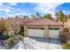 Three car garage, mature landscaping, and a concrete driveway at 2329 Quartz Peak St, Las Vegas, NV 89134