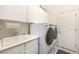 Bright laundry room featuring a sink, white cabinets, and a washer and dryer at 2329 Quartz Peak St, Las Vegas, NV 89134