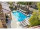 A swimming pool with a waterfall feature and spa is surrounded by a patio and desert landscaping at 2329 Quartz Peak St, Las Vegas, NV 89134