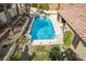 A sparkling pool with a waterfall feature is nestled among lush desert landscaping and a tiled patio at 2329 Quartz Peak St, Las Vegas, NV 89134