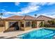 Backyard view of the pool, patio and red tile roof house with outdoor grill and seating area at 2329 Quartz Peak St, Las Vegas, NV 89134