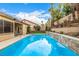 Backyard oasis with a pool, lush landscaping, and a covered patio at 2329 Quartz Peak St, Las Vegas, NV 89134