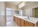 Bright bathroom features double sinks with wood cabinets and a large mirror at 2554 Corvus St, Henderson, NV 89044