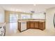 Bright open kitchen area with white dishwasher, wood cabinets, and a breakfast bar overlooking the living area at 2554 Corvus St, Henderson, NV 89044