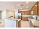 Bright kitchen featuring wood cabinetry, a breakfast bar, stainless steel appliances, and light-colored tile floors at 2554 Corvus St, Henderson, NV 89044