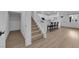 Open-concept living room with stairs, white cabinets, and breakfast bar with black counter stools at 2607 Aversa St, Henderson, NV 89044