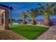 Stunning backyard showcasing synthetic lawn, pool with rock waterfall feature, and palm tree landscaping at 2820 Thunder Bay Ave, Henderson, NV 89052