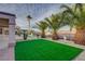 Beautiful backyard oasis features a synthetic lawn, desert landscaping, and a covered patio at 2820 Thunder Bay Ave, Henderson, NV 89052