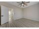 A light-filled bedroom with wood floors, ceiling fan, and an open doorway to another room at 2820 Thunder Bay Ave, Henderson, NV 89052