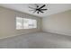 Bright bedroom featuring a large window, neutral carpeting, and a modern ceiling fan at 2820 Thunder Bay Ave, Henderson, NV 89052