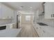 Bright kitchen with white cabinets, stone backsplash, stainless appliances, and wood floors at 2820 Thunder Bay Ave, Henderson, NV 89052