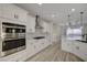 Bright kitchen with white cabinets, stone backsplash, stainless appliances, and wood floors at 2820 Thunder Bay Ave, Henderson, NV 89052