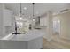 A modern kitchen featuring white cabinets, quartz countertops, stainless steel appliances, and pendant lighting at 2820 Thunder Bay Ave, Henderson, NV 89052