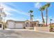 Elegant home featuring a three-car garage, desert landscaping, and a grand entrance with palm trees at 379 Turquoise Ct, Boulder City, NV 89005