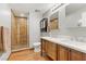 Bathroom with double vanity, wood-look tile, and glass shower at 4075 E Oquendo Rd, Las Vegas, NV 89120